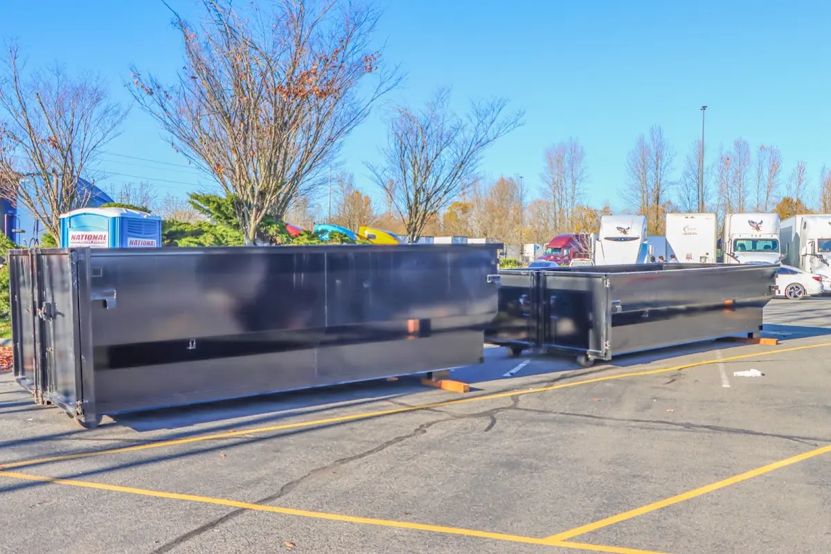 Professional dumpster rental service with roll-off container on residential driveway in Grand Blanc